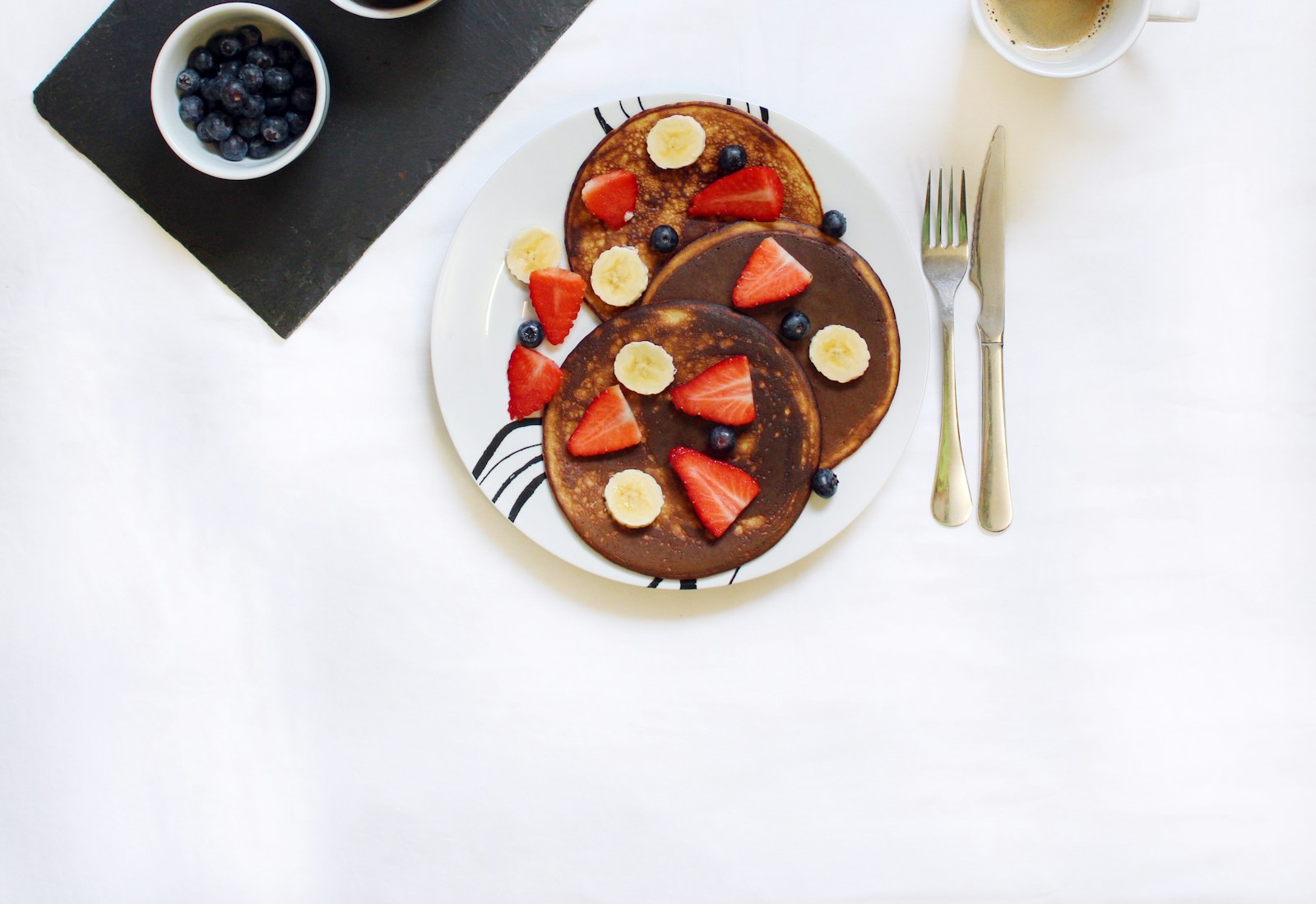 Pancakes and a cup of coffee on a breakfast table
